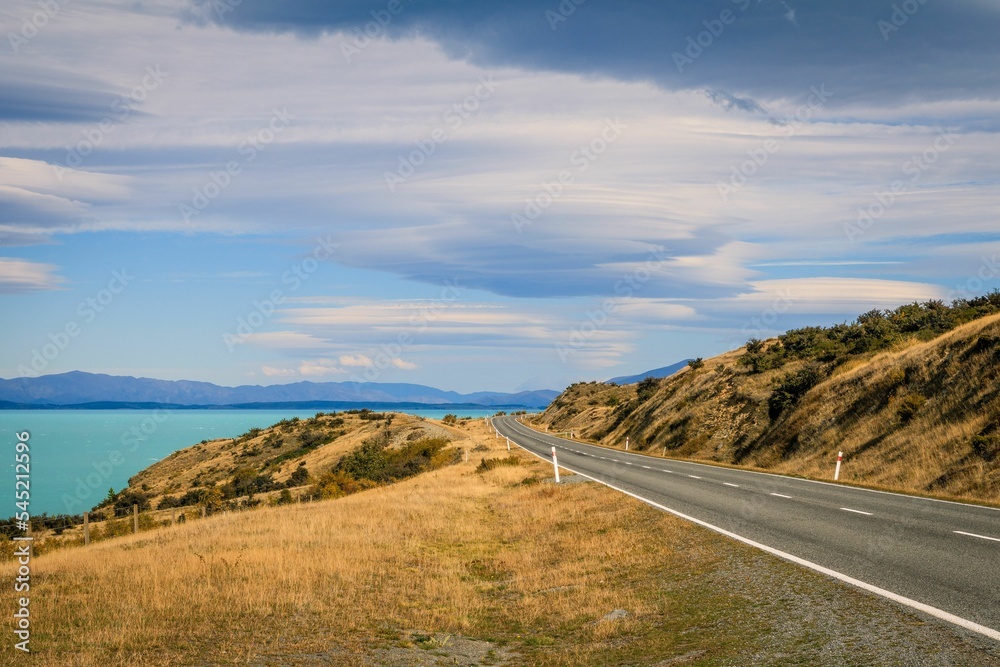 Scenic view of an asphalt road near the beach in Glentanner, New Zealand on a cloudy day