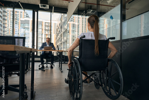 Woman in wheelchair applying for job in office