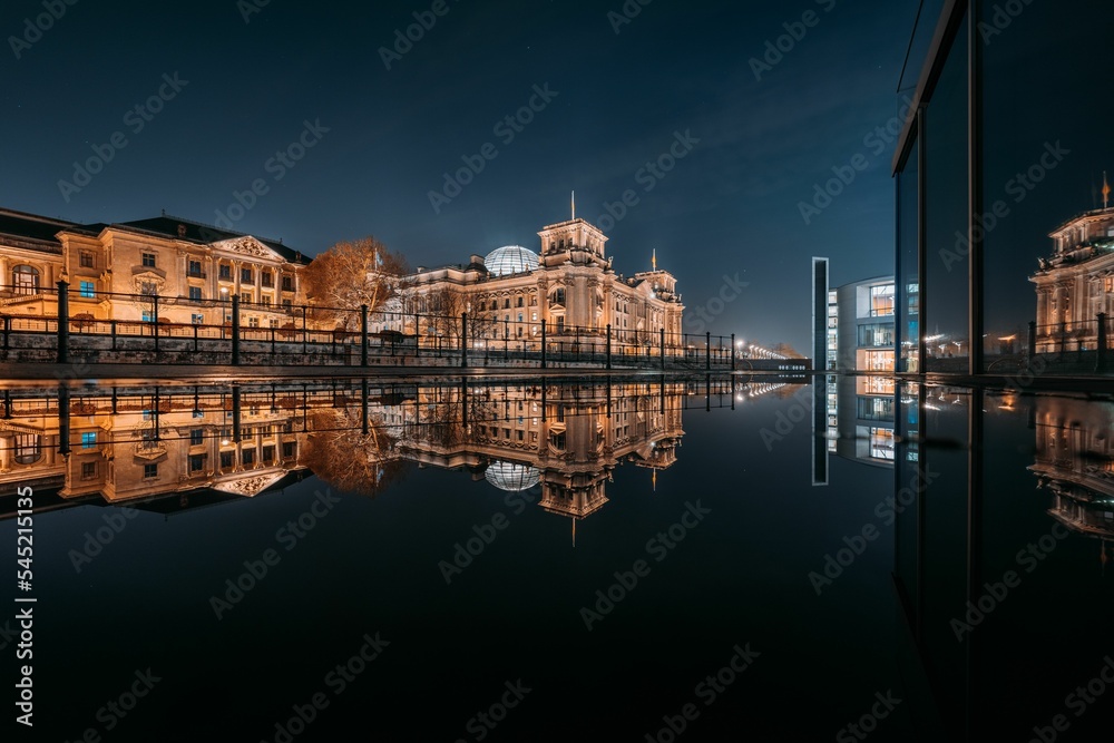 Naklejka premium Reflection of the Reichstag building on the Spree River at night