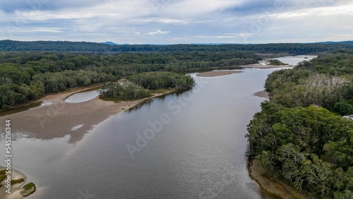 Aerial shot of the Lake Cathie surrounded by lush trees in New South West, Australia