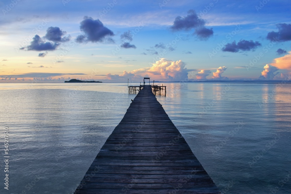 Wooden pier within colorful sunset - Raja Ampat, West Papua, Indonesia