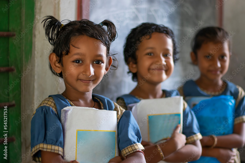 Three School Children's holding books standing