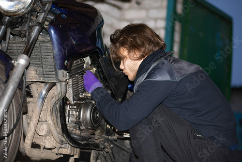 motorcycle repair by a man in the garage.