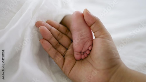 Close up father and mother hands holding newborn baby feet over black background, copy space background banner family parents love concept.