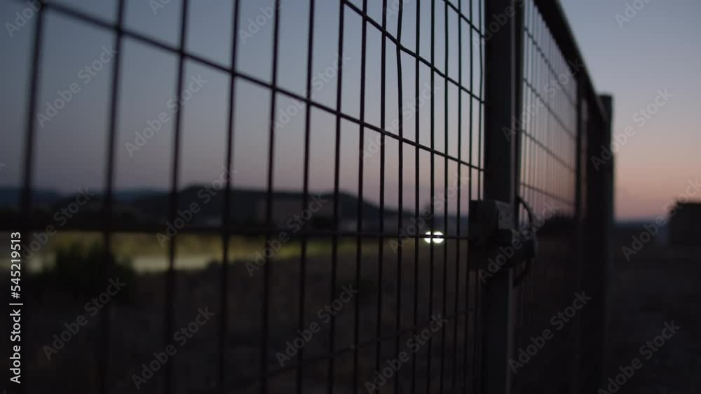 Wire metal fence and country road in the dusk Wire metal fence and country road in the dusk