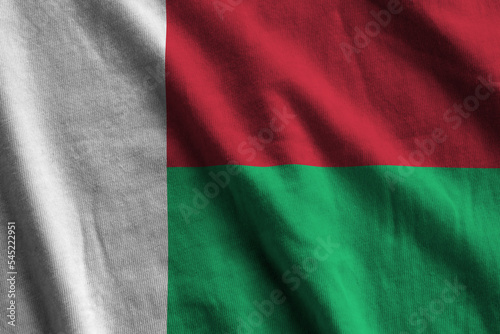Madagascar flag with big folds waving close up under the studio light indoors. The official symbols and colors in banner photo