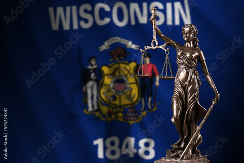 Wisconsin US state flag with statue of lady justice and judicial scales in dark room. Concept of judgement and punishment photo