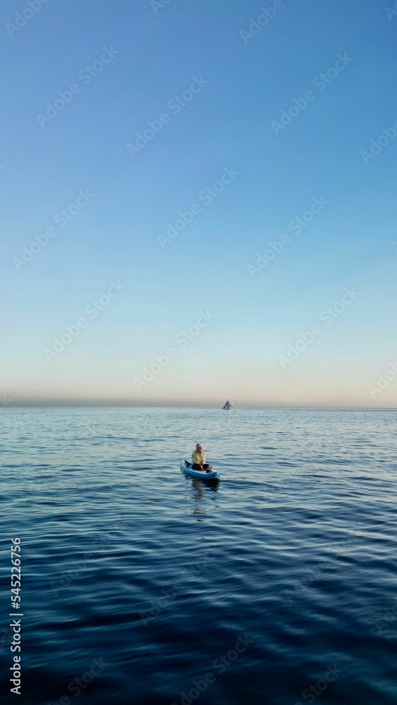 Vertical shot of a person in a kayak floating on the water in Bali, Indonesia