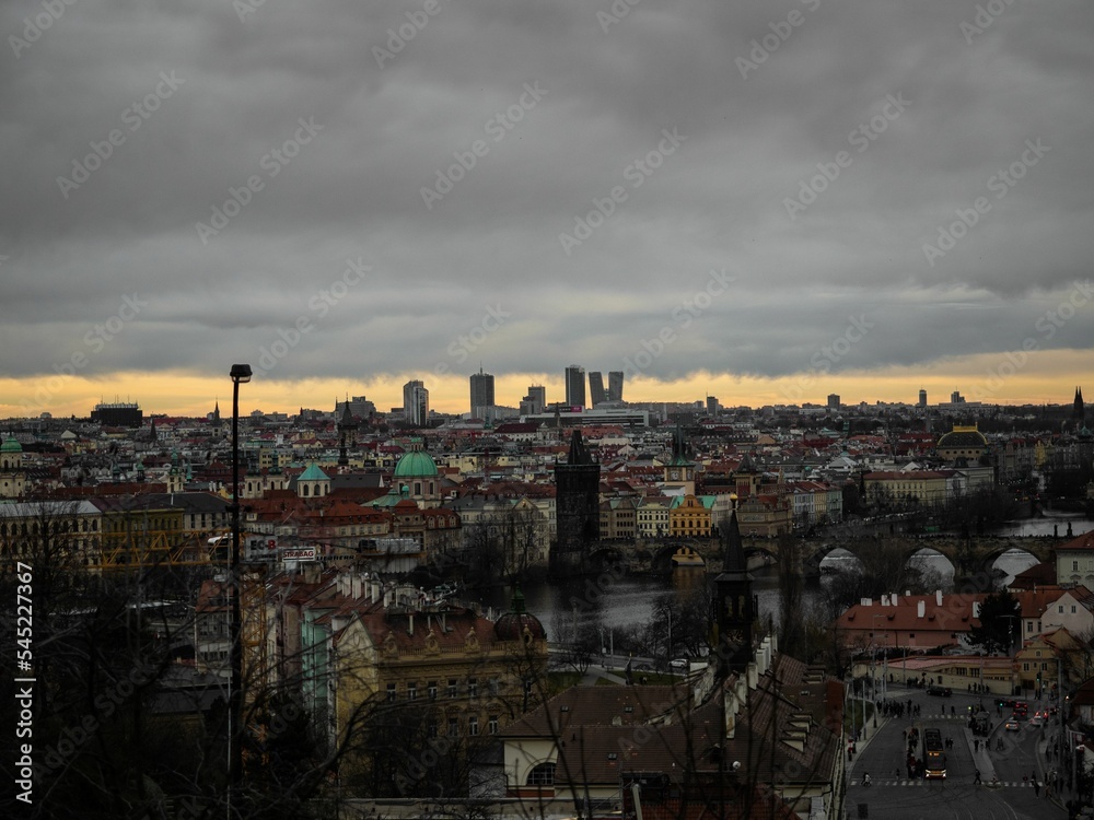 Aerial view of Prague cityscape during dark gray cloudy sunset on a gloomy day