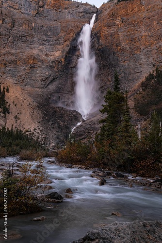 Vertical shot of a waterfall flowing down between cliffs