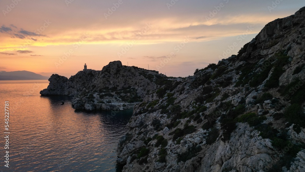 Natural view of a calm coast and rocky island during sunset