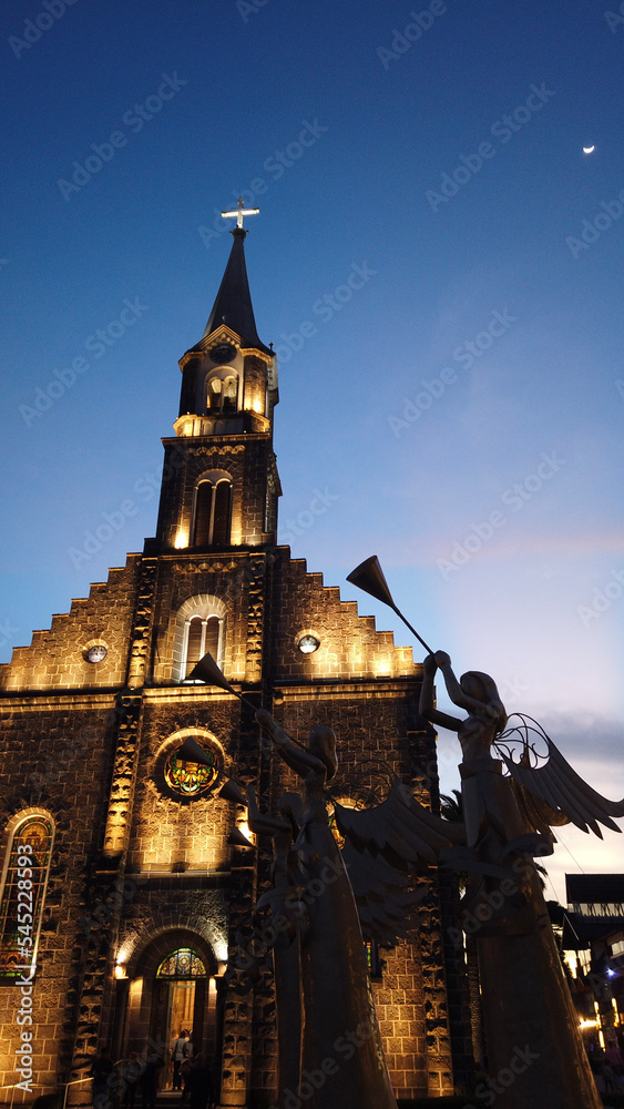 Naklejka premium Matriz Church in the center of Gramado city, Rio Grande do Sul lit up at night on a beautiful day with a clear sky