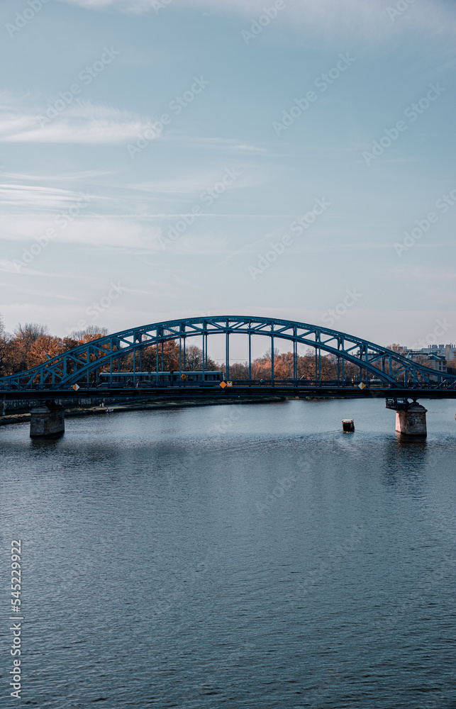 iron bridge over river with tram and autumn colors
