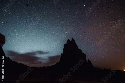 Silhouette of a rocky mountain under the starry night sky