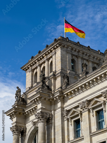 German Parliament building in Berlin with German flag flying proudly above it.