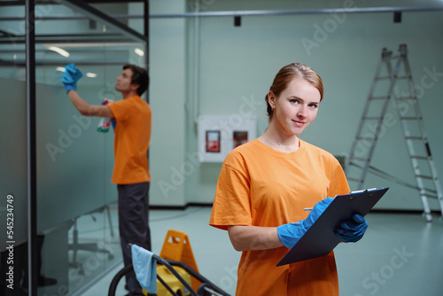 Professional cleaners accomplishing corporate request according to the checklist photo
