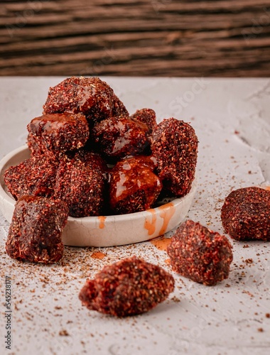Vertical closeup of natural tamarind with chili powder and chamoy on the white table photo