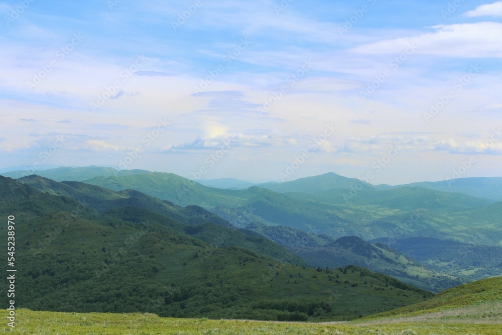 Fototapeta premium Beautiful shot of a green landscape under the white clouds