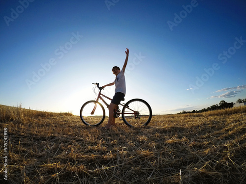 menino com bicicleta por do sol 