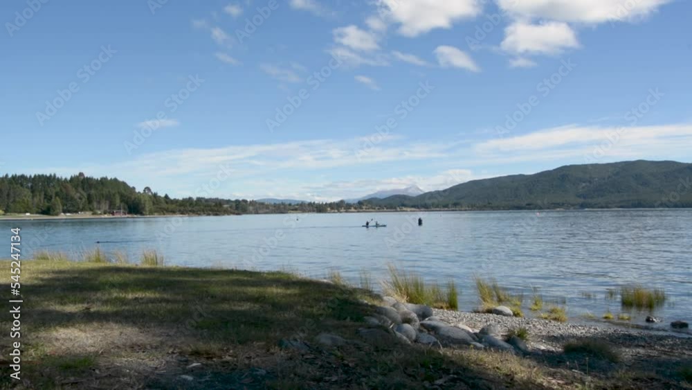 Te Anau townscape with the lake near, trees, clear, sunlit sky background Te Anau townscape with the lake near, trees, clear, sunlit sky background
