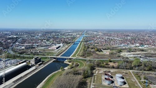 Aerial shot of a river with a bridge with a cityscape in the background