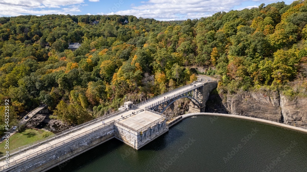 Drone shot of the New Croton Reservoir and dam on a sunny day in autumn with a blue cloudy sky