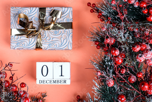 1 december calendar and christmas present on orange background with christmas tree decor