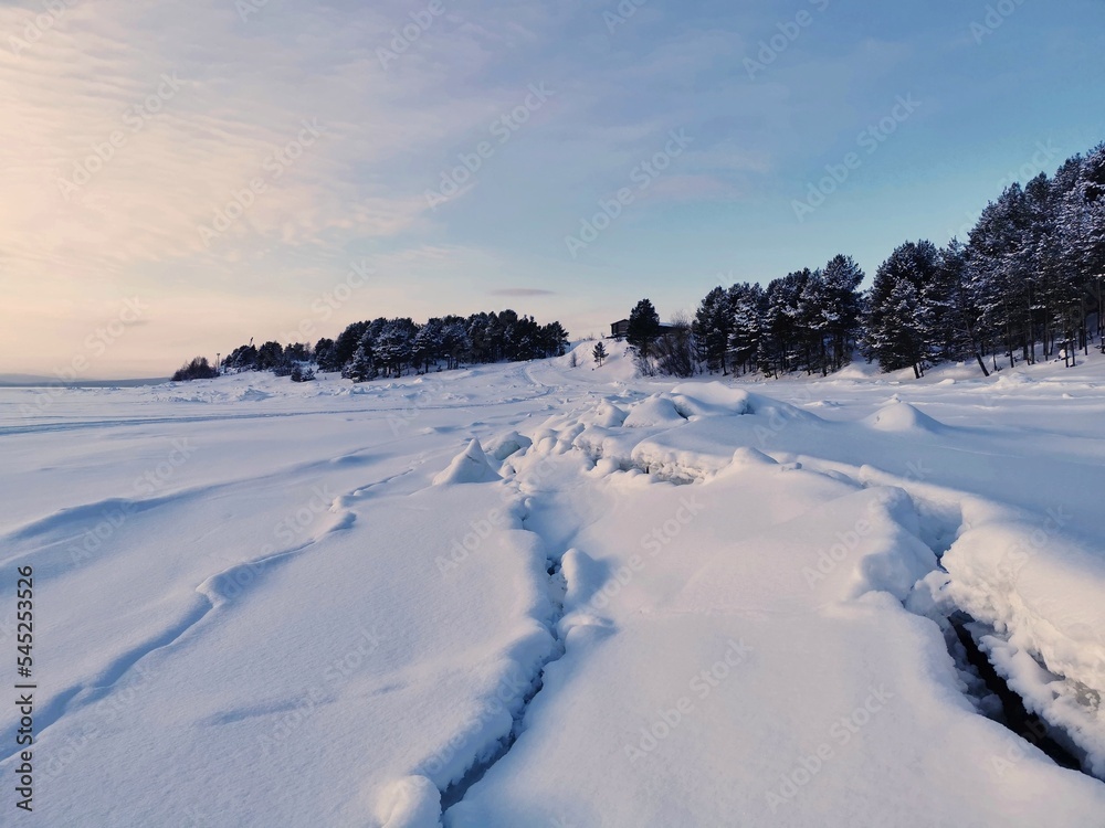 Winter landscape in Kandalaksha, Kola Peninsula, Murmansk region. Cracks in the ice of frozen White sea.
