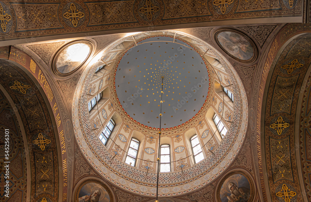 Helsinki, Finland - July 20, 2022: Uspenski Cathedral. Vertical shot inside into central circular dome structure with heavenly ceiling and windows. Paintings of saints in corners between 4 giant bows