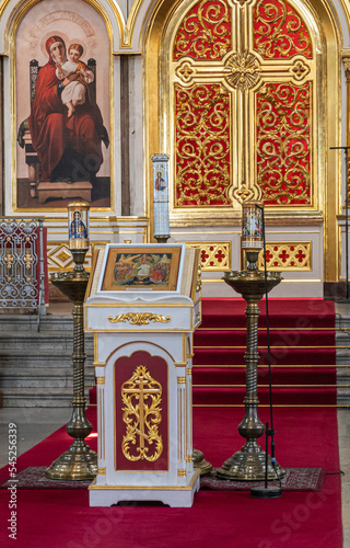 Helsinki, Finland - July 20, 2022: Uspenski Cathedral. Lecture stand in front of entrance to sanctuary with Madonna painting on side and pictured candles in massive stands photo