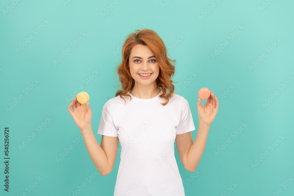 happy woman hold sweet macaron french cookie on blue background happy woman hold sweet macaron french cookie on blue background