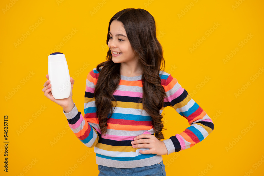 Child with shampoo conditioner. Daily cosmetic care. Teenager kid 12, 13, 14 years old hold bottle of hair and skin care. Beauty health and cosmetics. Happy teenager. Child with shampoo conditioner. Daily cosmetic care. Teenager kid 12, 13, 14 years old hold bottle of hair and skin care. Beauty health and cosmetics. Happy teenager.