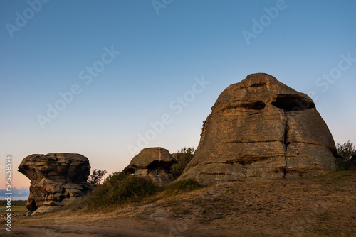 Sacred rocks, mountains in the shape of a head illuminated by the setting sun. Rock mountain cliff over sunset sky background A place of power. A place of worship.