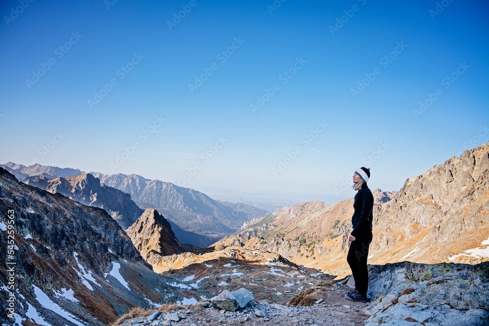 Woman hiking in the Slovak Tatra Mountains in autumn. Beautiful mountain view of the Slovak part of the Tatra Mountains Woman hiking in the Slovak Tatra Mountains in autumn. Beautiful mountain view of the Slovak part of the Tatra Mountains