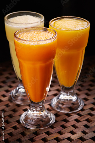 Assortment slush of Orange Mango Pineapple cocktail soda Drink served in glass isolated on table side view of middle east food