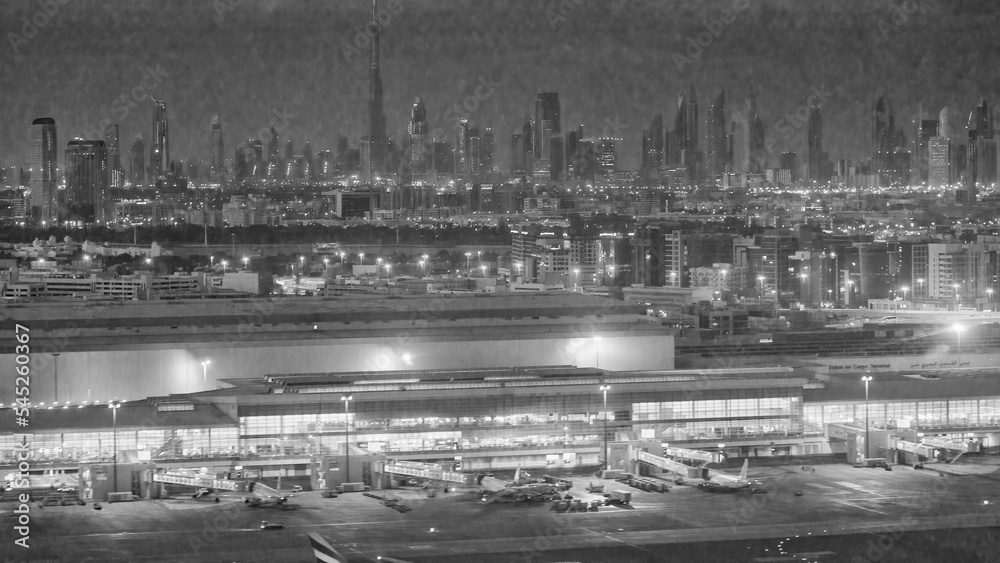 Dubai airport at night with city skyline in the background