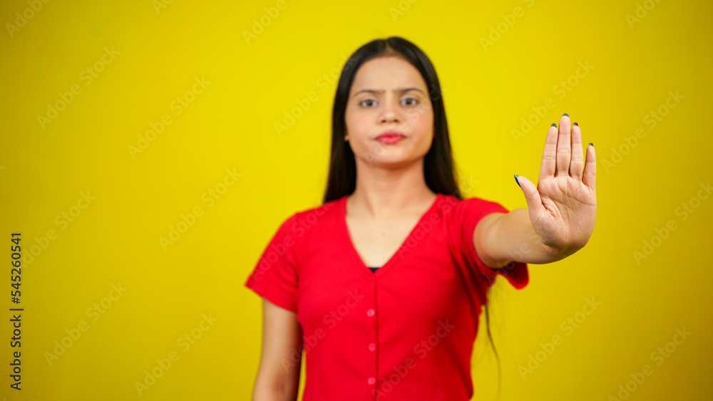 Portrait of a Asian beautiful young woman unhappy or confident standing say no, studio shot isolated yellow background, Indian female pose saying reject gesture with copy space Portrait of a Asian beautiful young woman unhappy or confident standing say no, studio shot isolated yellow background, Indian female pose saying reject gesture with copy space