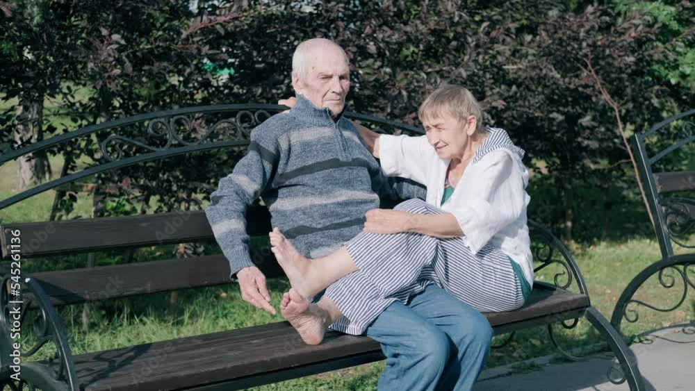 Old people couple, husband and wife sitting on park bench talking and enjoying sunny day Old people couple, husband and wife sitting on park bench talking and enjoying sunny day