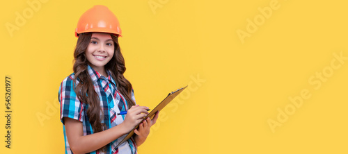 signing a contract. on construction site. future engineer hold clipboard. safety work expertise. Child builder in helmet horizontal poster design. Banner header, copy space.