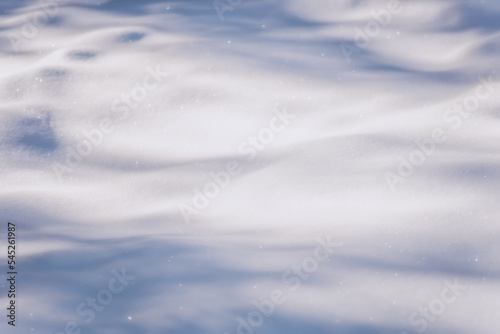 White snow in sunlight on a clear frosty day. Shadows on the snow. Bright snowy background with empty field for montage. Christmas background with snow. Natural wallpape