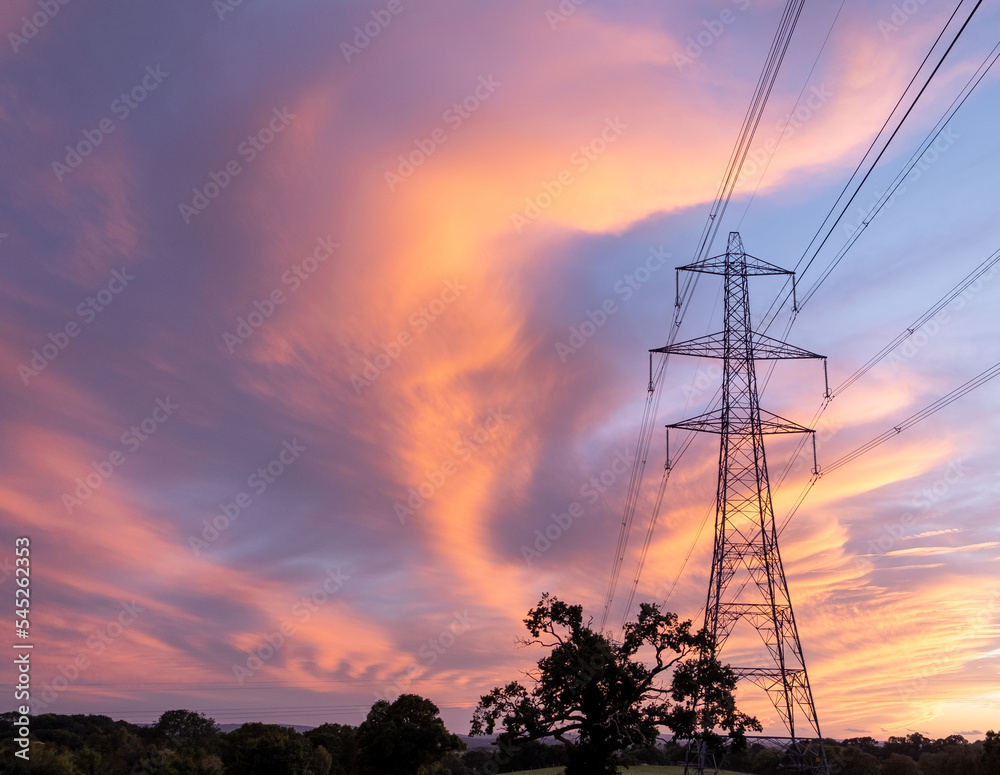 Electricity pylons at orange sunset