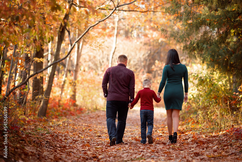 Autumn family walk in the park, where there are many yellow trees and bright plants around