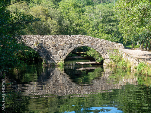 Puente de piedra cruzando el r  o con reflejos