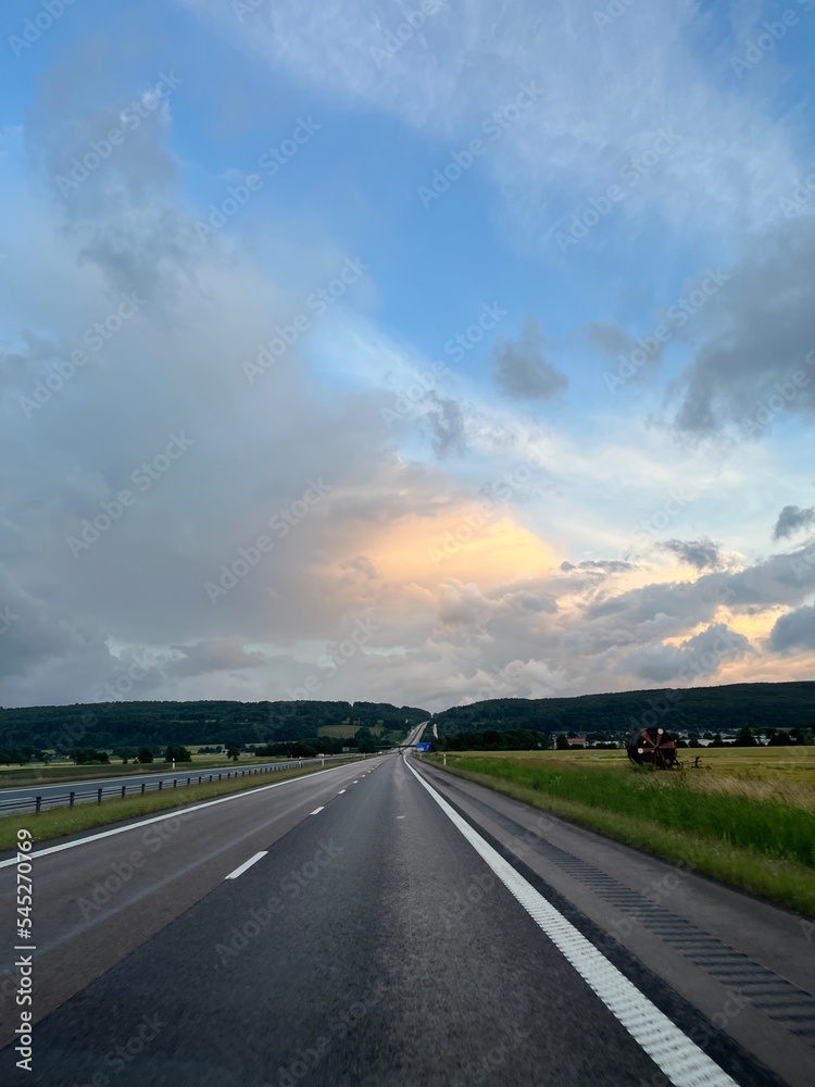 Empty highway in the fields, stormy sky