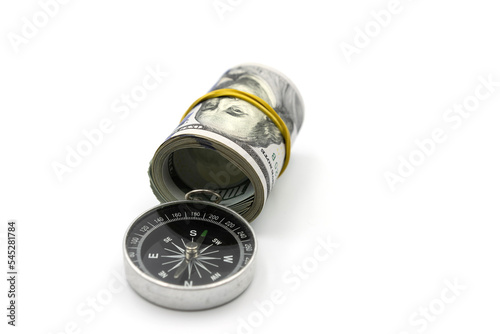 Classic navigation compass and bundle of money roll of dollars isolated on white background