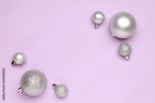 Wallpaper greeting card Merry Christmas holiday composition with silver toy ball decoration on lilac background. Xmas New Year winter design idea concept. Top view, Flat lay. Copy space for text