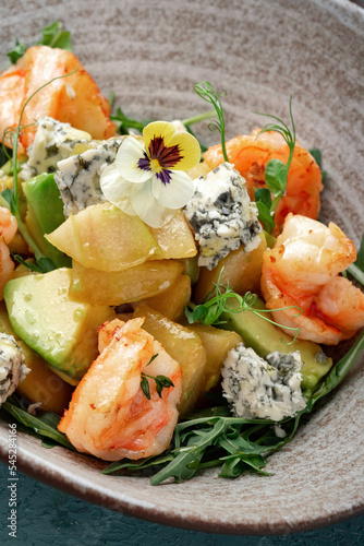 Salad with pear, avocado, shrimp, arugula and gorgonzola cheese. Italian diet salad close up