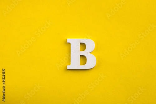 letter B uppercase - white wood letter on yellow color background