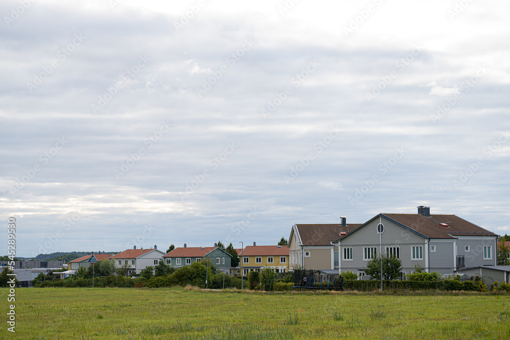 Row of residential houses by a green field. Row of residential houses by a green field.