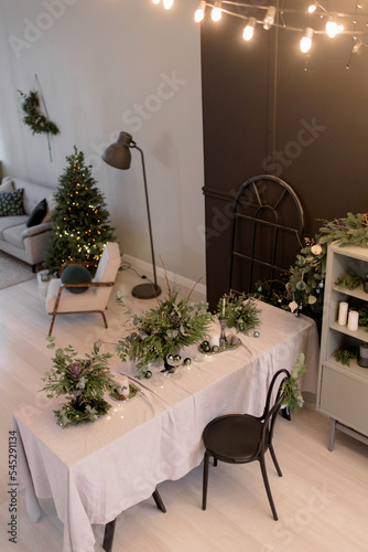 Festive New Year's table with candles and handmade Christmas decorations and live floristry